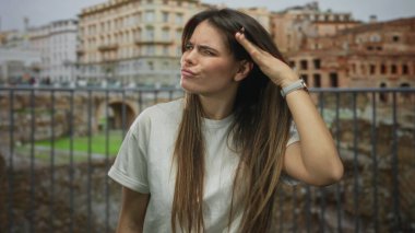 Roma harabelerinin önünde el kol hareketi yapan İspanyol kadın, şehrin arka planına karşı çeşitli duygular ifade ediyor..