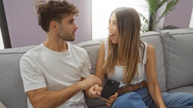 Kadın, erkeğin oturma odasında heyecan verici bir şey gösterirken neşeli ve sevgi dolu bir çiftin evdeki mutlu ilişkilerini yansıttığını söylüyor..