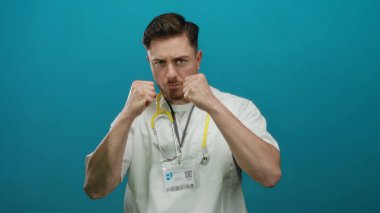 Beyaz önlüklü ve steteskoplu genç bir doktor, izole edilmiş mavi bir arka plana karşı, güç ve güven yansıtan bir savaş duruşu benimsiyor..