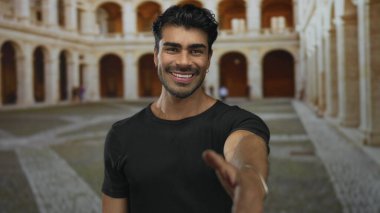 İnsan, tarihi bina avlusunda el sıkışmak için sağ elini uzatıyor. Sabah güneşinde yıkanan avluda. Arkadaşlık..