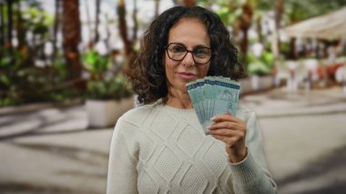 Malezya sirkesi banknotlarını elinde tutan kadın şehir merkezinde bir sokakta para ve finansman gösterisi yapıyor..