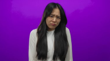 Mor bir arka planda gülümseyen genç Çinli kadın neşeli duygular ve canlı bir kişilik ifade ediyor..