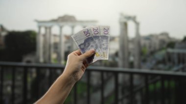 Atina 'da Akropolis' te arka planda partenon olan İsviçre kronu banknotları tutan adam..