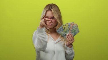 Elinde Romen lei banknotları tutan genç bir kadın sağlam yeşil bir zemine karşı, gözlük takıyor ve neşeli bir tavır sergiliyor..