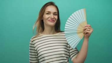 Kadın hayranlar, turkuaz stüdyoda çizgili bluz giyerken elde tutulan vantilatörle yüzyüze geliyorlar; ferahlatıcı ferahlatıcı ferahlatıcı.