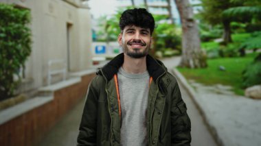 Genç bir adam sokak gösteriş cazibesine ve karizmasına sıradan bir ortamda jest yapıyor.