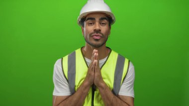 Yeşil stüdyoda sıkı sıkıya bağlı elleri olan mühendis gözleri kapalı ve yansıtıcı yelek giyiyor. Umut..
