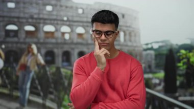 Roma 'daki tarihi Roma Kolezyumu' nun önünde tefekkür eden genç adam.