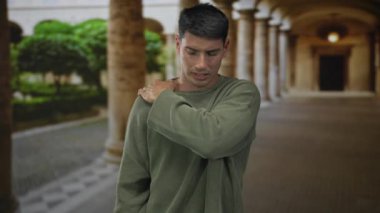 Eski üniversite binası koridorunda yeşil kazaklı adam el ele verip acı çekiyor..