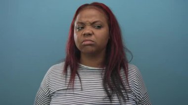 Kadın kulaklarını tıkar burnu burnu buruşmuş, kaşları çatık, parmaklarını kulaklarının derinliklerine bastırır..