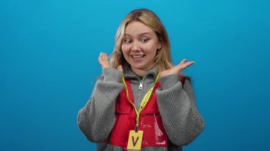 Mavi arka planda kırmızı yelek giyen, çeşitli duyguları ifade eden, sarı saç ve günlük kıyafetlerle tanımlanan, neşeli ve nişanlı bir tavrı vurgulayan gönüllü bir kadın..