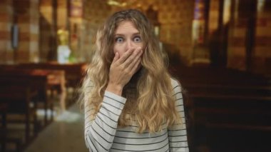 Kadın, kutlama sırasında genç, sarışın ve mutlu bir iç yüzle kilisede şaşırmış gibi görünürken ağzını kapatır..