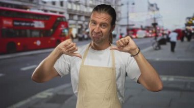 Önlük giyen adam yoğun caddede kırmızı çift katlı otobüsle baş parmak hareketi gösteriyor; reddedilme reddedilme reddi onaylanmadı.