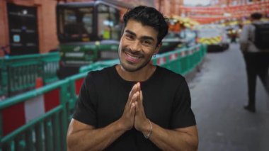 Siyah gömlekli genç adam şehir caddesinde açık el hareketi sergiliyor; belirsizlik sorusu kafa karışıklığı.