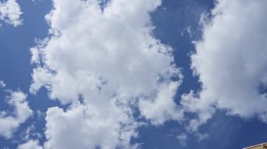 Pofuduk beyaz bulutlar açık mavi gökyüzüne yayılır güneşli bir günde, bu güzel bulutlu ortamda kusursuz dingin doğal bir manzaranın özünü yakalar..