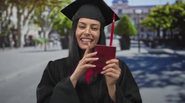 Mezuniyet şapkalı ve cüppeli genç İspanyol kadın şehir caddesinde Fransız pasaportu taşıyor. Bu da uluslararası seyahat ve açık hava akademik başarısını gösteriyor..