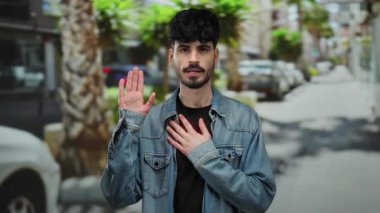 Latin kökenli genç bir adam şehir sokaklarında el üstünde bir söz veriyor. Şehir manzarasında, sıradan bir kot ceketle samimiyet sergiliyor..