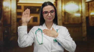 Beyaz önlüklü, steteskoplu bir kadın kilisenin iç kısmında duruyor, el göğsünde yemin işareti var, kırmızı gözlüklü, kutsal ortamda profesyonel görünümü arttırıyor.