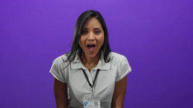 İp takan genç bir kadın, canlı mor bir arka plana karşı heyecanlı bir şekilde alkışlıyor, ıssız bir yerde şaşkınlık ve neşe taşıyor..