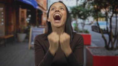 Canlı bir şehir caddesinde neşeli bir heyecan ifade eden bir kadın canlı bir çevre ve neşeli bir atmosfer, açık havada mutluluk duygusunu artırıyor..