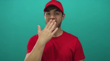 Kırmızı şapkalı ve tişörtlü İspanyol genç adam ağız üstüne stüdyo, neşeli bir hareketle gülümsüyor; sessizlik..