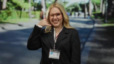 Parkta beni işaret eden bir kadın beni arıyor. Üzerinde iş elbisesi ve kimlik kartı olan bir kadın. Gözlükleriyle güvenle gülümsüyor..