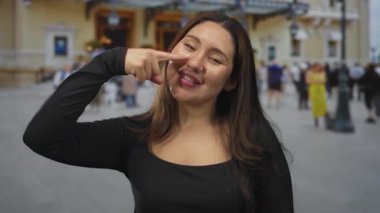 Şehrin işlek caddesinde yürüyen bulanık kalabalıkla burnu işaret eden genç İspanyol kadın; neşe.