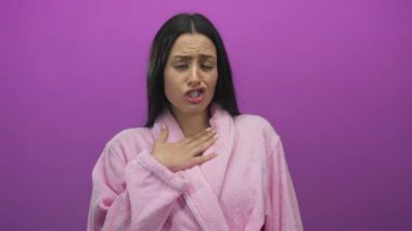 Pembe bornoz giymiş pembe bir kadın pembe bir arka plan karşısında şaşırmış yüz ifadeleri ile farklı duygular uyandırıyor. Şok ve heyecan gibi..