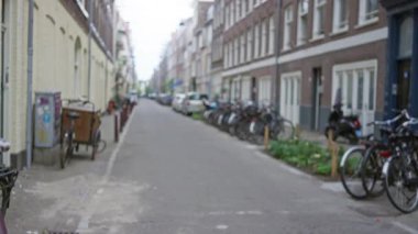 Bulanık bisikletleri, binaları ve kaldırımlı bir yolu olan Avrupa kentsel sokak sahnesi, dağıtılmış bir şehir manzarasında mimari ve ulaşım sergilenen günlük hayatı yakalıyor..