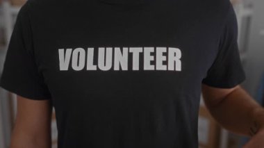 Gönüllü gömlekli bir adam kırmızı kalp taşıyor. Kamu alanındaki bağlılığı sembolize ediyor. Hizmet yoluyla fedakarlık ve nezaketi vurguluyor..