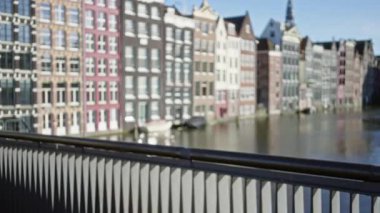 Renkli cepheli Amsterdam Kanal Evleri 'nin bulanık görüntüsü, su boyunca ikonik mimari sergileniyor..