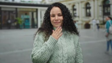 Yeşil kazaklı genç bir kadın caddede dolanıyor. Ağzını kapatarak şaşkınlığını dile getiriyor. Şehir geçmişi şehir bağlamını ve modern duyguları da ekliyor..