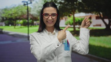 Üniformalı İspanyol kadın bilimadamı, güneşli bir park ortamında doğal bir ortamın altını çizen keşif ya da heyecanı dile getirirken şaşırdı ve yan yan gösterdi..