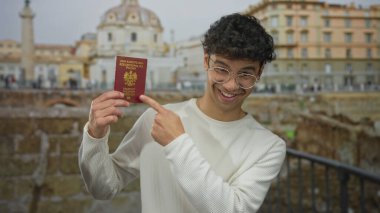 Beyaz kazak giyen ve elinde pasaport olan bir adam Roma binasını işaret ediyor. Seyahat macerası..