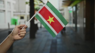 Bir şehir caddesinde el ele tutuşmuş bayrak şehir manzarasının ortasında beyaz bir adamın kutlamalarını ve gururunu simgeliyor..