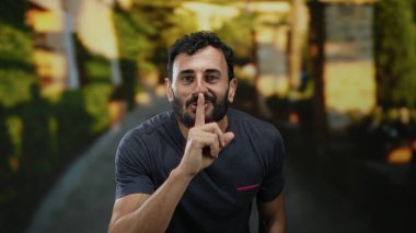 Sokakta sakallı İspanyol bir adam sessizce el sallıyor.