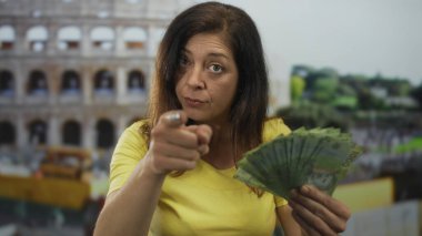 İspanyol kadın Roma Kolezyumu 'ndaki bir binanın önünde Şili pezosu fanı tutuyor. Açgözlülük..