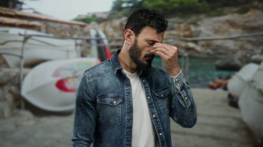 Limanın yanında sakallı İspanyol bir adam duruyor. Gemilerin ve dalgalı denizin ortasında bitkinlik ve deniz havası yayıyor..