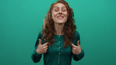 Canlı yeşil bir arka plan karşısında heyecanlı jestler yapan kadın kıvırcık saçlarını ve hareketli bir portrede canlandırılmış yüz ifadelerini vurguluyor..
