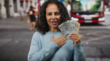 Peru banknotlarını açık hava otobüs durağında tutan kadın, mali tatmini simgeliyor, kentsel bir ortam ile çevrili, para birimi ve yerel çevreyi vurguluyor..