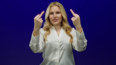 Mavi arka plana karşı neşeli jest yapan kadın mizahı ve meydan okumayı vurguluyor.