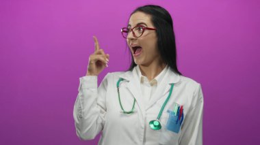 Pembe arka planda steteskop takan kadın doktor, düşünceli ve yenilikçi sağlık hizmetleri profesyonelini temsil ediyor..