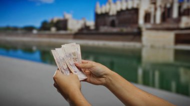 İkonik Mallorca katedralinin önünde el ele tutuşan eller, pitoresk bir şehir ortamında turizm ve finansal alışverişi vurguluyor..