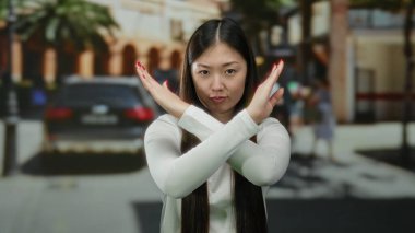 Şehir sokaklarında kendine güvenen bir kadın, şehir geçmişi ve arabaları tasvip etmediğini ifade ediyor, günlük kıyafetler giyiyor, modern şehir yaşam tarzını yansıtıyor..