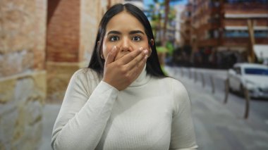 Kadınlar el ele tutuşup şaşkın şaşkın bakıyorlar. Sokakta, genç Latin asıllı, açık havada ağzı kapalı..