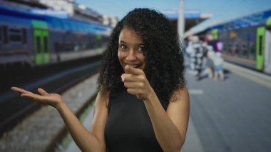 Gülümseyen genç İspanyol kadın trenin girişini işaret ederek, seyahat tutkusu macera yolculuğu.