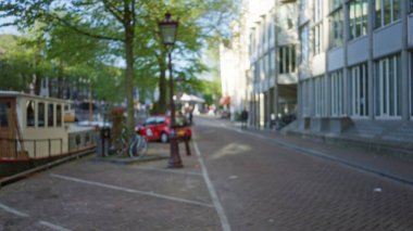 Amsterdam caddesinin bulanık manzarası. Çözünmüş kanallar, bisikletler ve mimari, Hollanda 'nın başkentinde kentsel yaşam ve sükuneti yakalıyor..