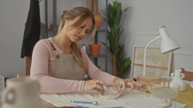 Stüdyoda çıplak elle küçük ıslak kil kabı şekillendirir; yaratıcılık dikkat çekiciliğine odaklanır.