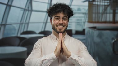 İspanyol adam modern bir restoran ortamında el ele meditasyon yapıyor, kafeterya ortamında huzur ve yansıma yayıyor..