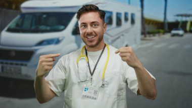 Steteskoplu genç sakallı erkek doktor arka planda bir araçla bir şehir sokağında gülümseyip kendini işaret ederek açık hava sağlık hizmetlerine güvendiğini ima ediyor..